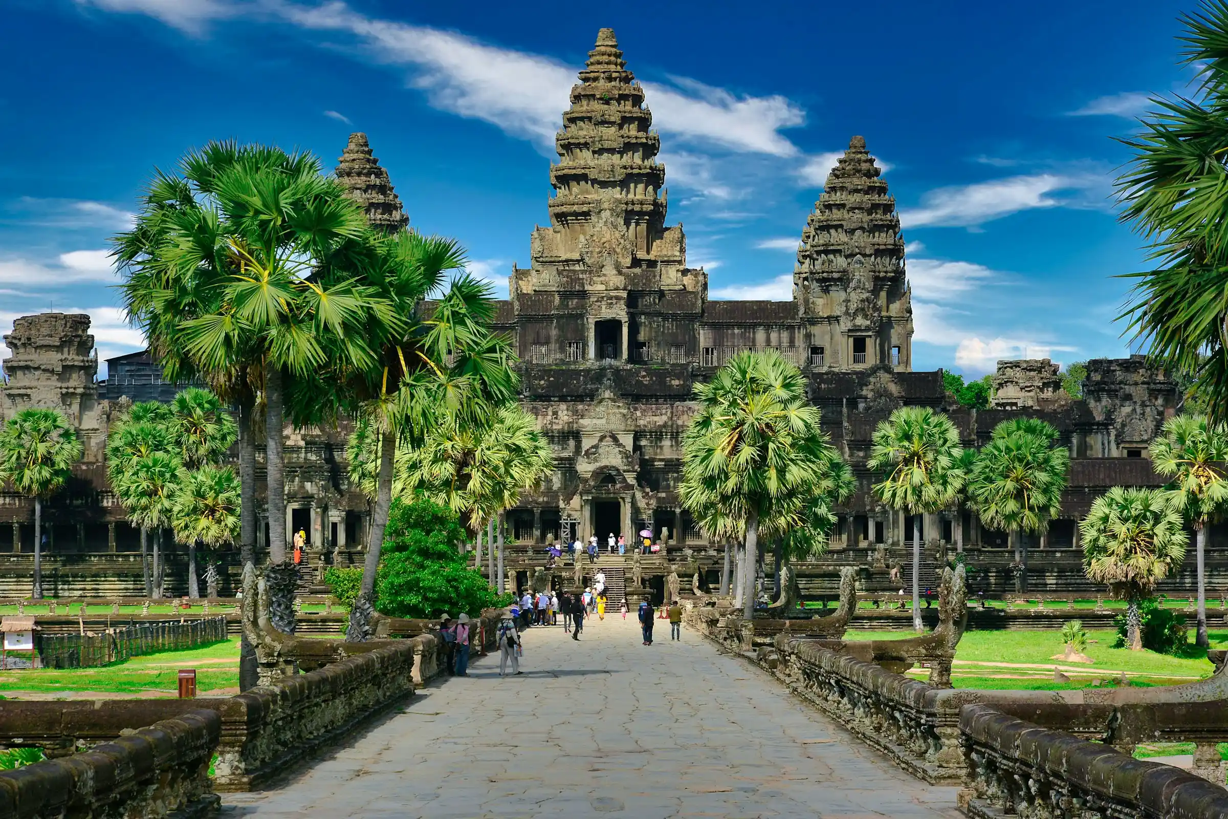 The towers of Angkor Wat temple beyond a palm-lined causeway, Cambodia
