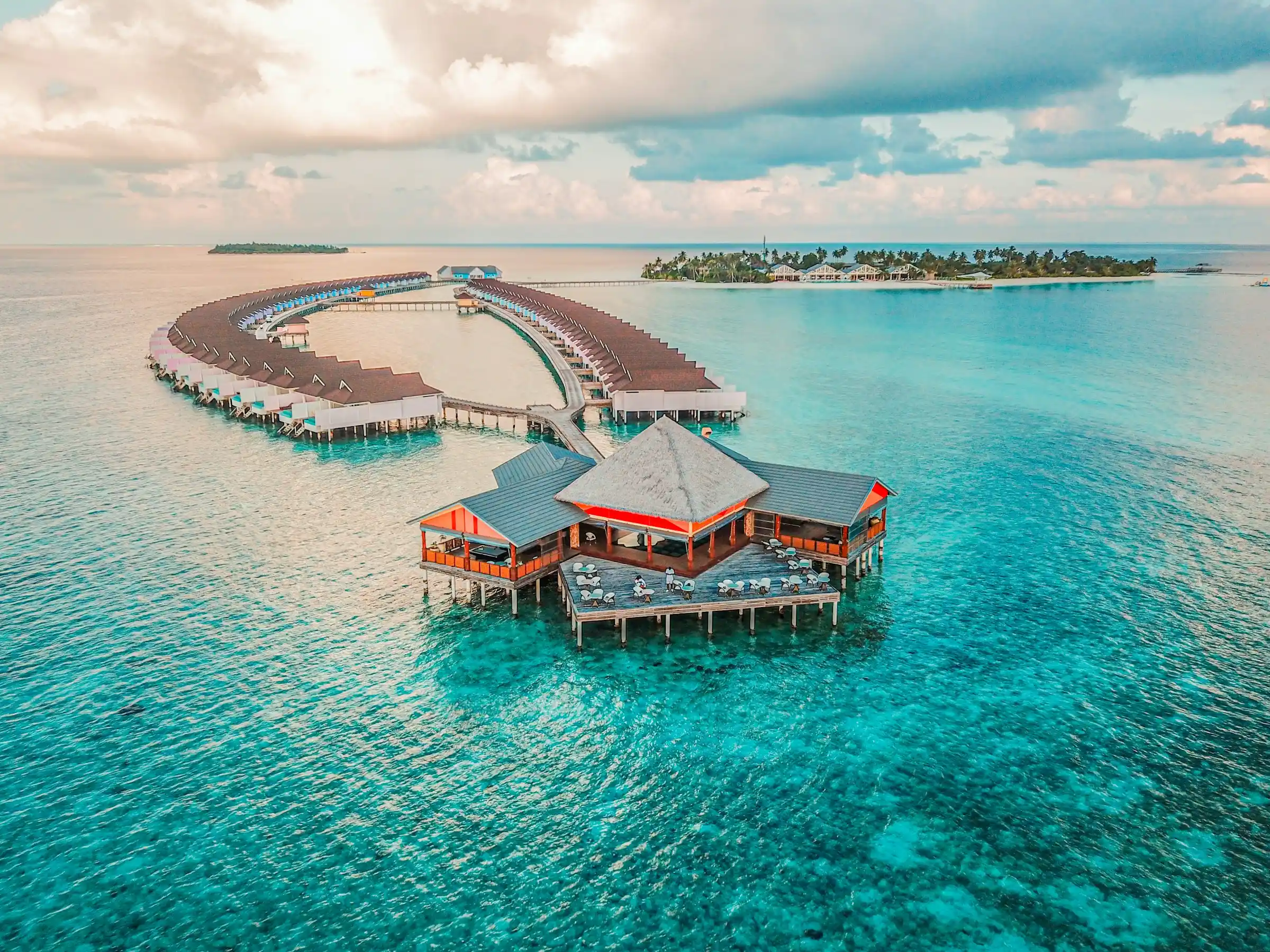 Aerial view of overwater villas in a turquoise lagoon at a Maldives island resort