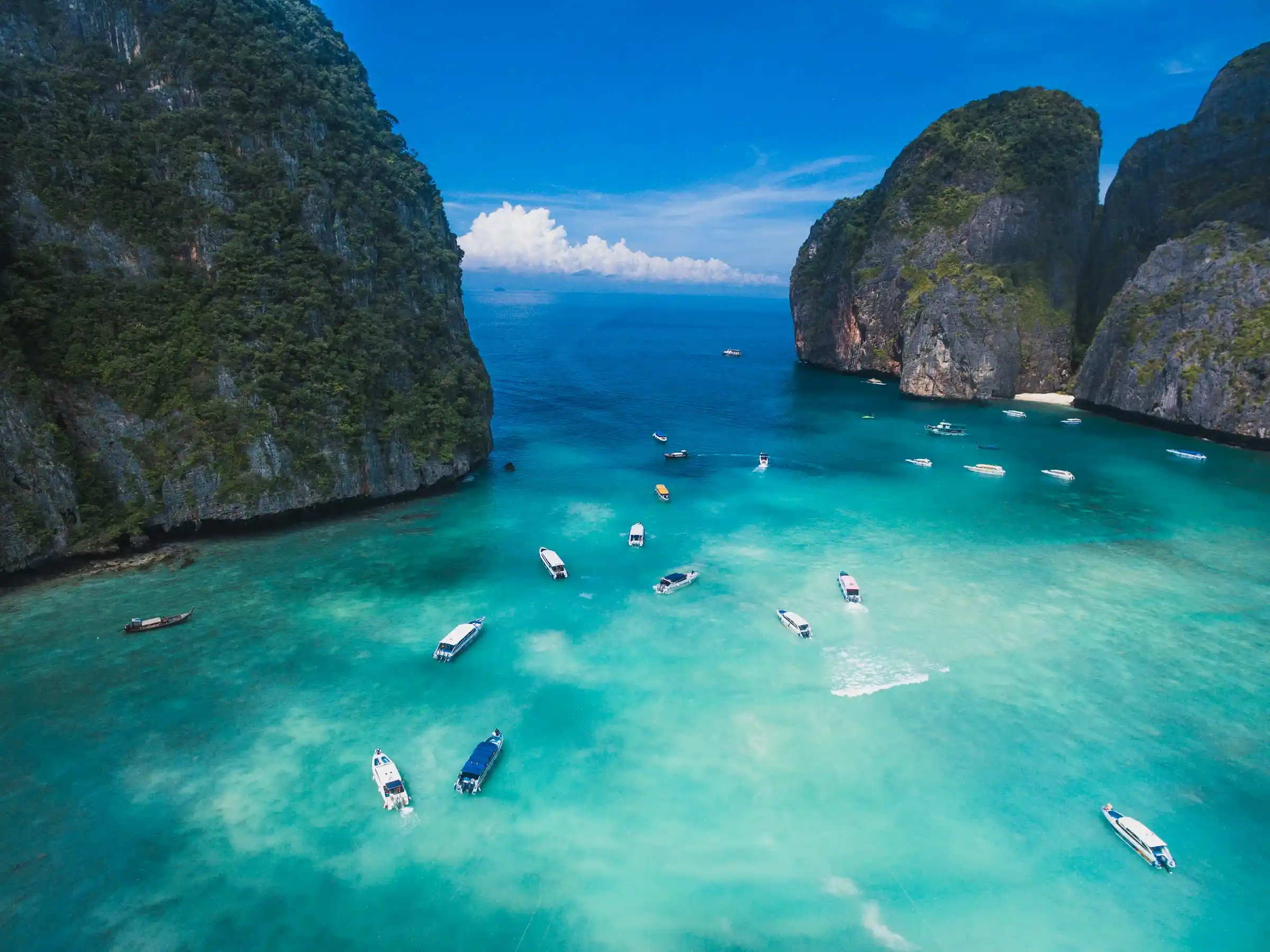 Speedboats in the turquoise water of a limestone bay in the Phi Phi Islands, Thailand