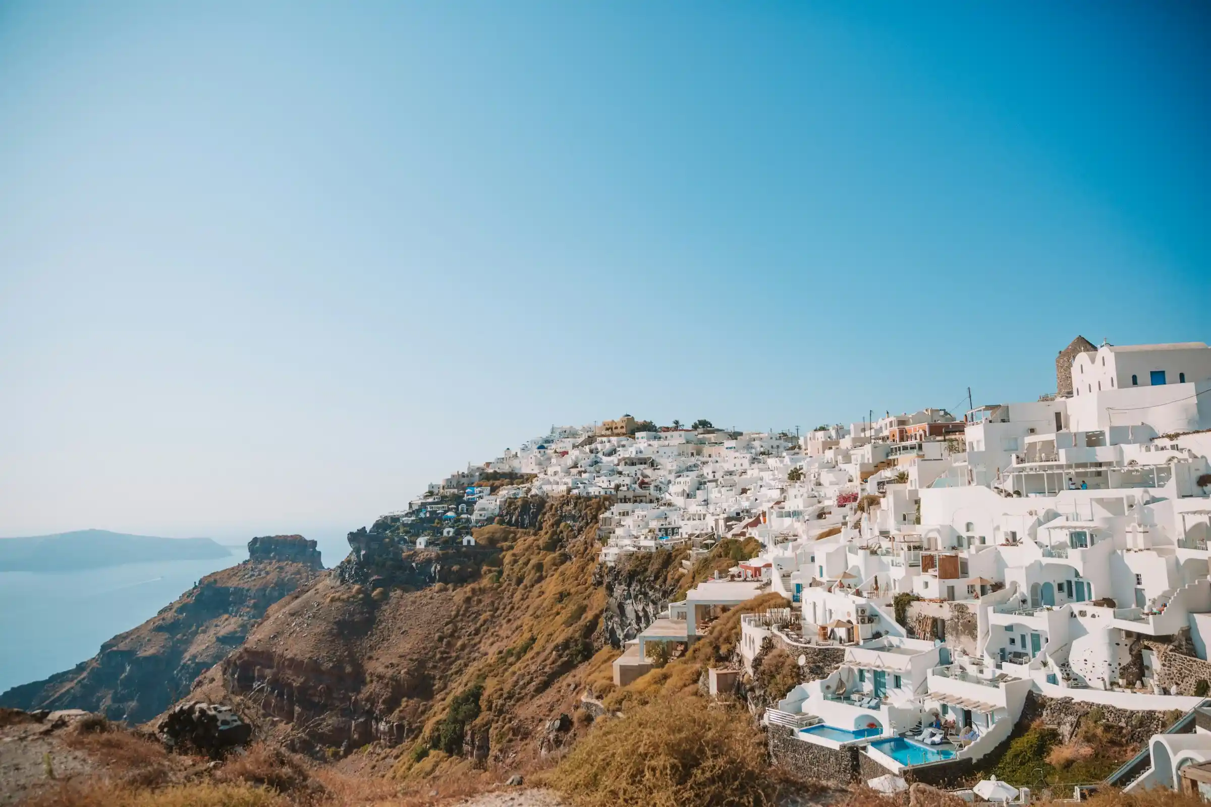 Greek island with white-washed buildings and blue sea in June