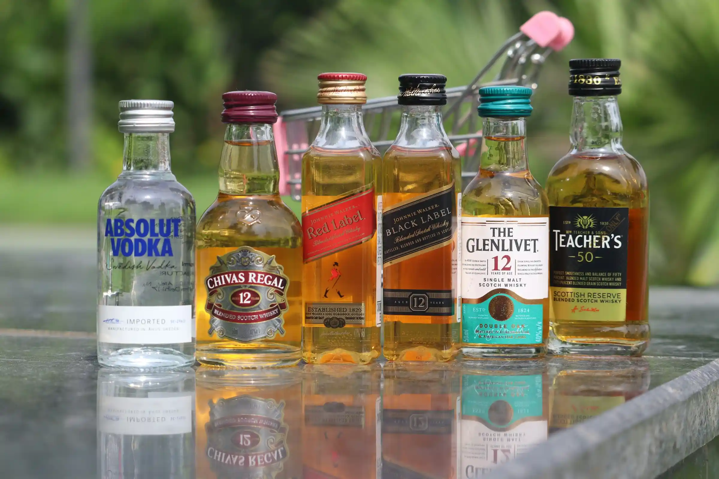 A row of miniature spirit bottles of vodka and whisky