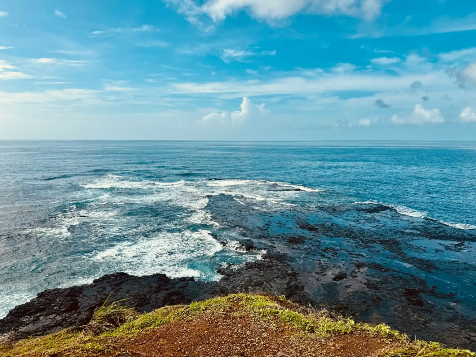 Rocky volcanic coastline and open ocean seen from a clifftop viewpoint, Fernando de Noronha