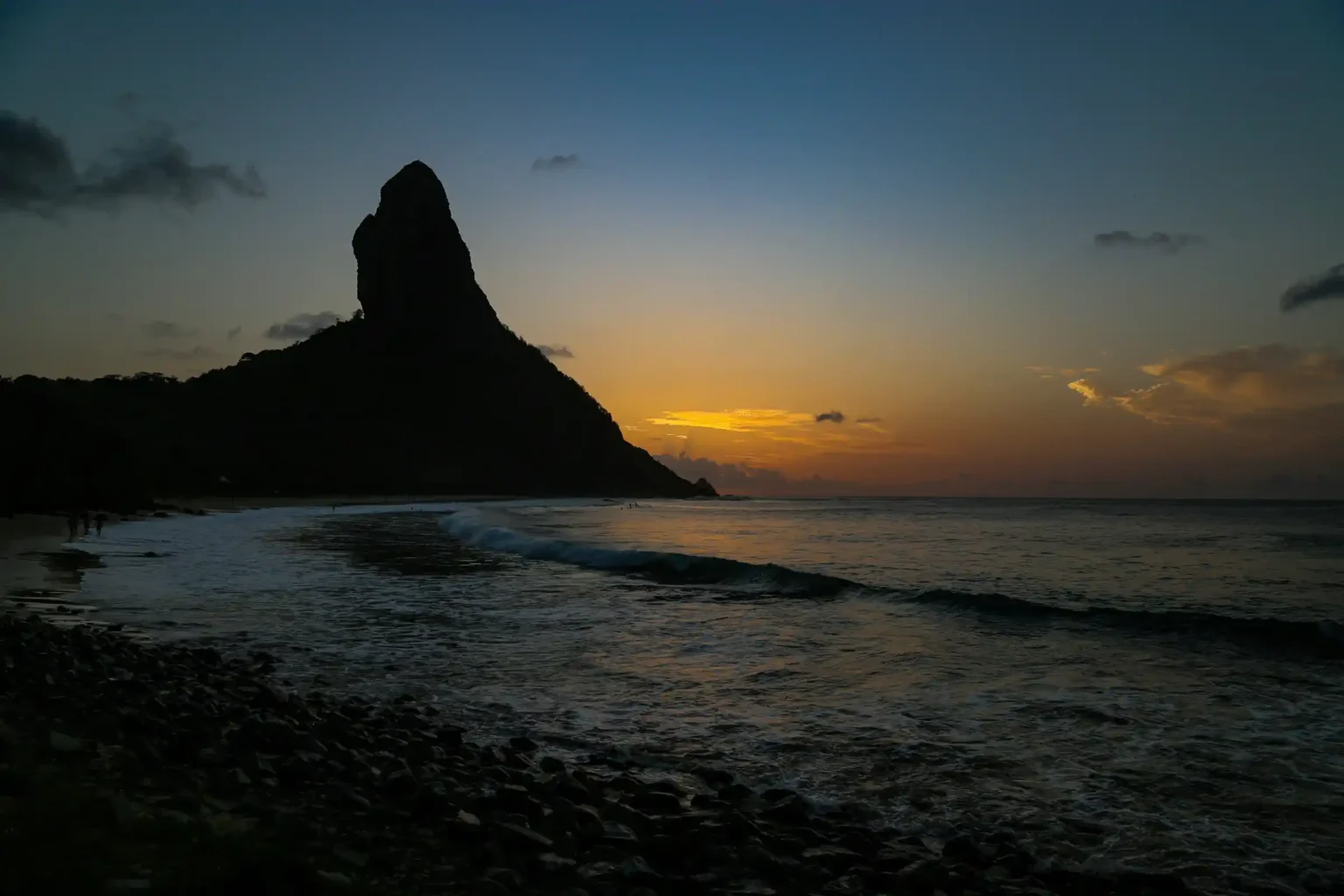 Sunset silhouette of Morro do Pico over the sea, Fernando de Noronha, Brazil