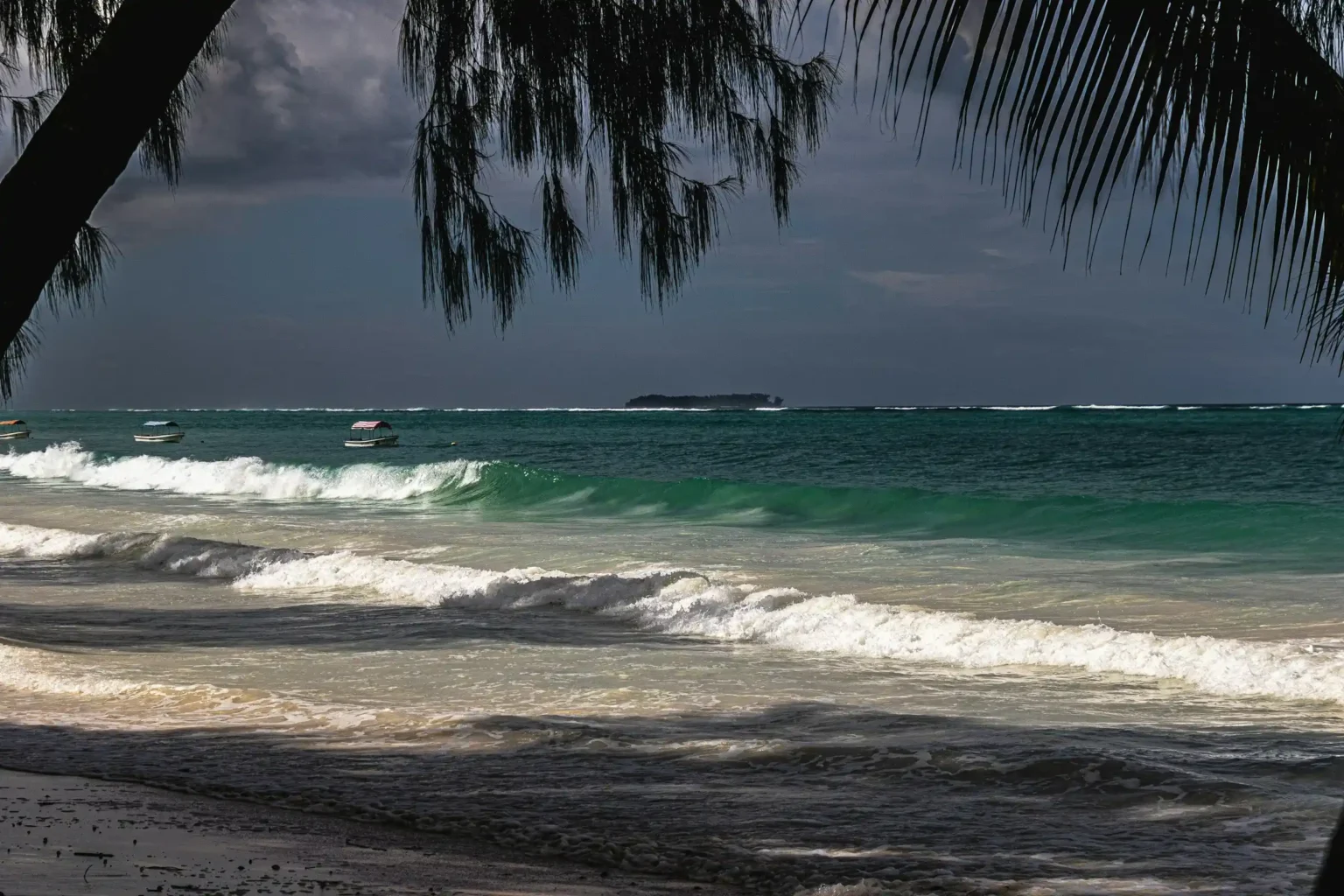 Matemwe Beach on the northeast coast of Zanzibar with a traditional dhow and Mnemba Island in the distance