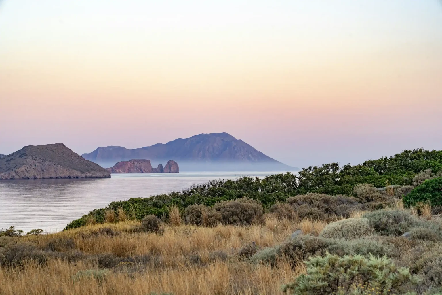 Calm pastel dusk over the sea and rocky islets of Milos