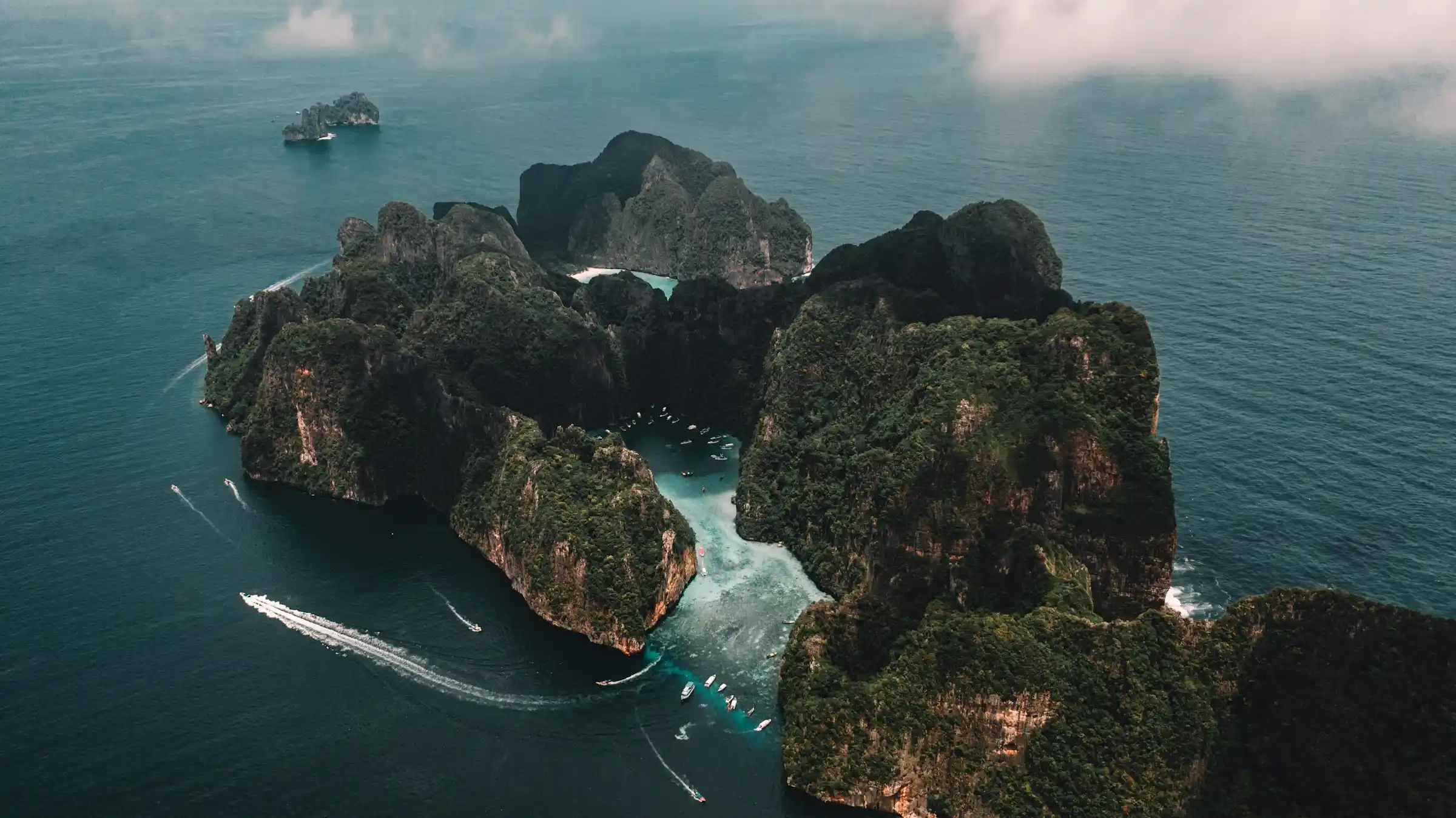 Aerial view of Phi Phi Leh island with boats gathered around Maya Bay and Pileh Lagoon
