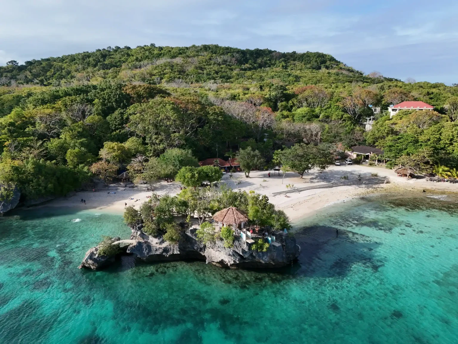 Aerial view of Salagdoong Beach and its rocky islet in turquoise water, Siquijor