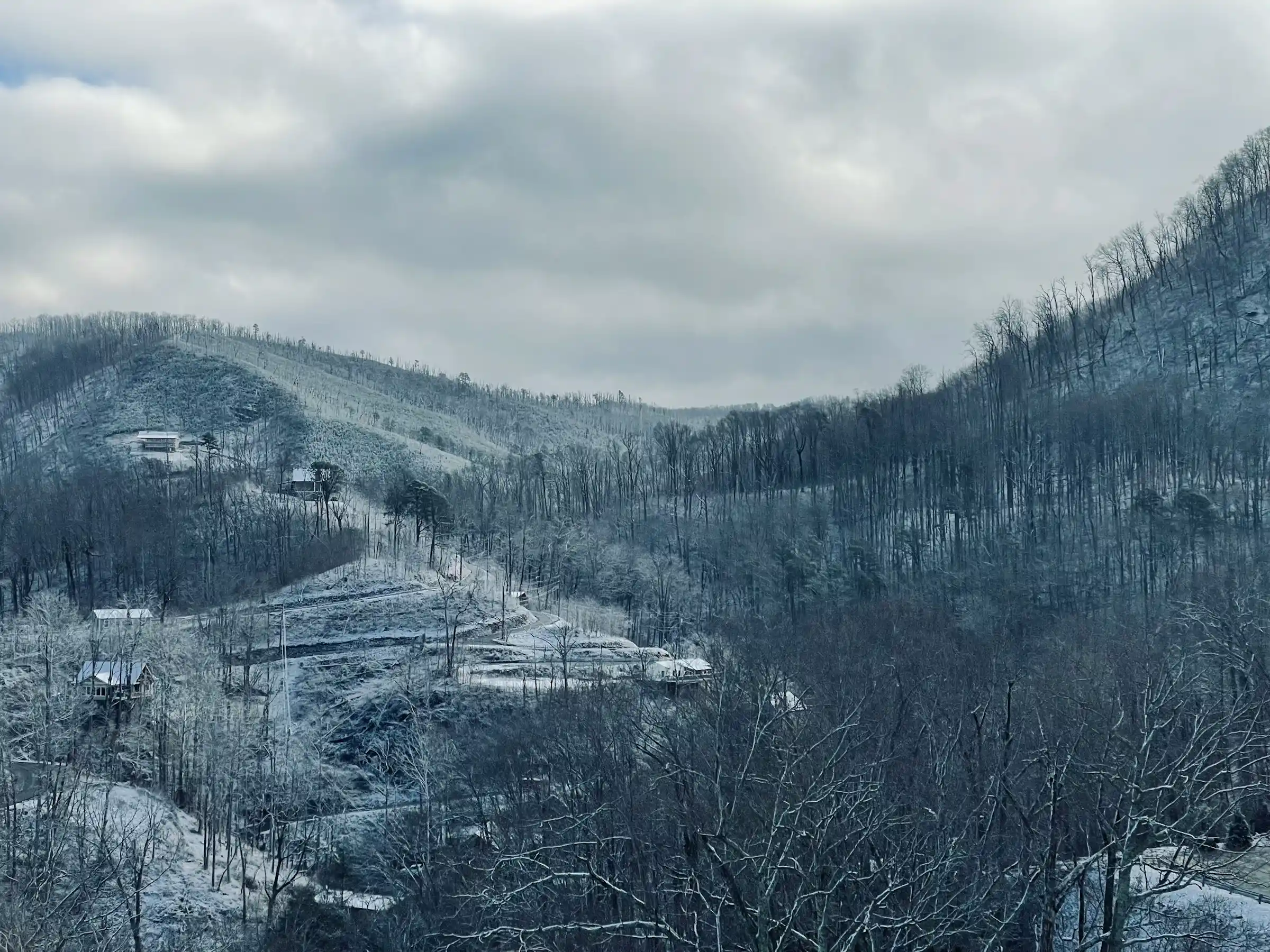 Snow-dusted Smoky Mountain valley with cabins on forested hillsides in winter above Gatlinburg