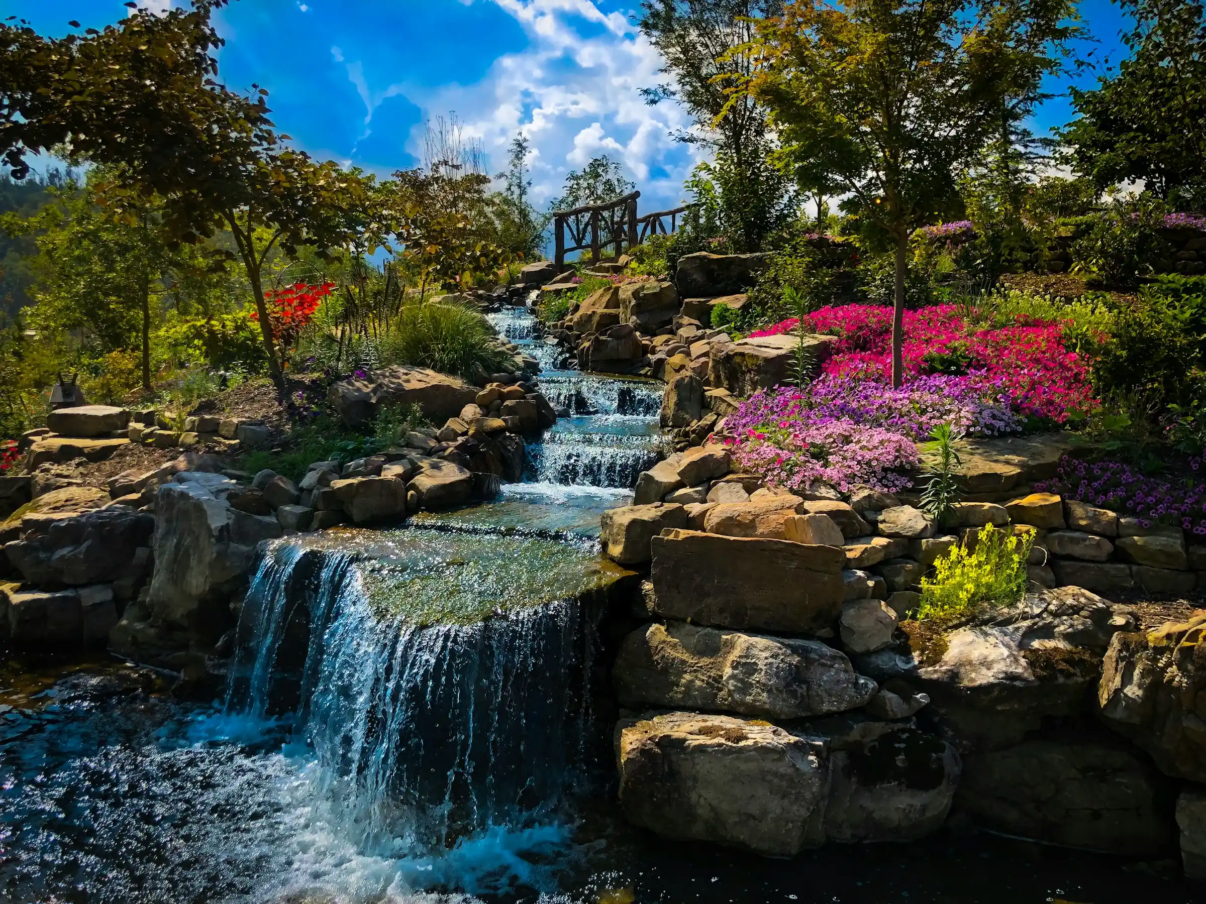 Landscaped garden waterfall with pink and purple flowers at a Gatlinburg mountaintop park