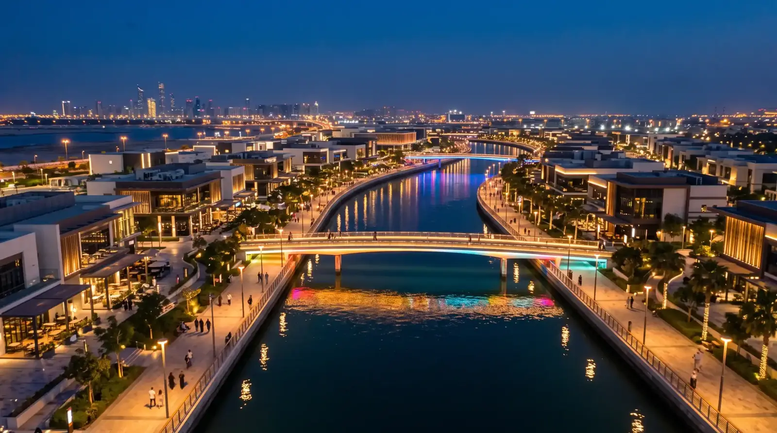 Aerial drone night view of glowing Al Qana canal and bridges in Abu Dhabi