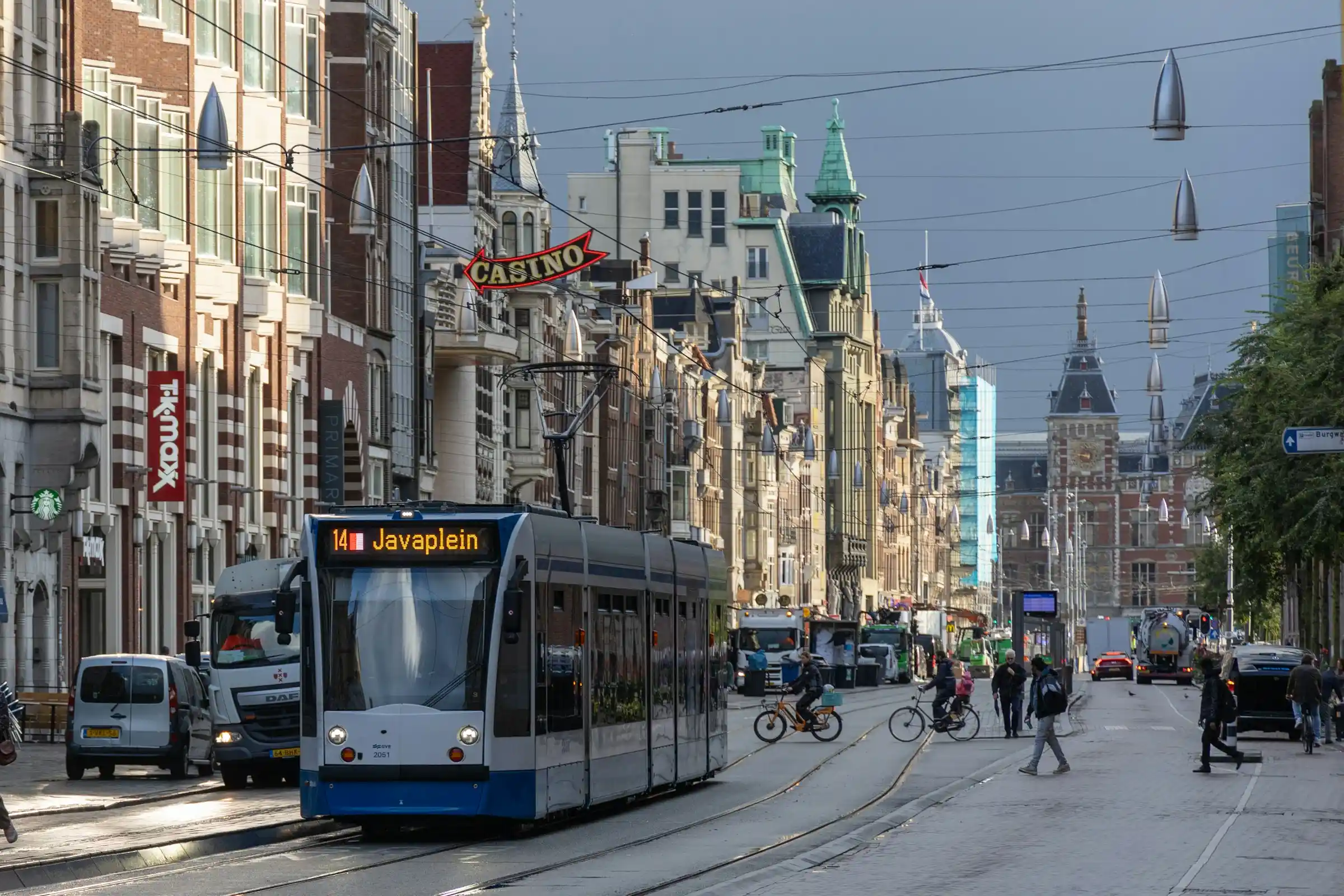 A blue and white GVB tram on a street in central Amsterdam