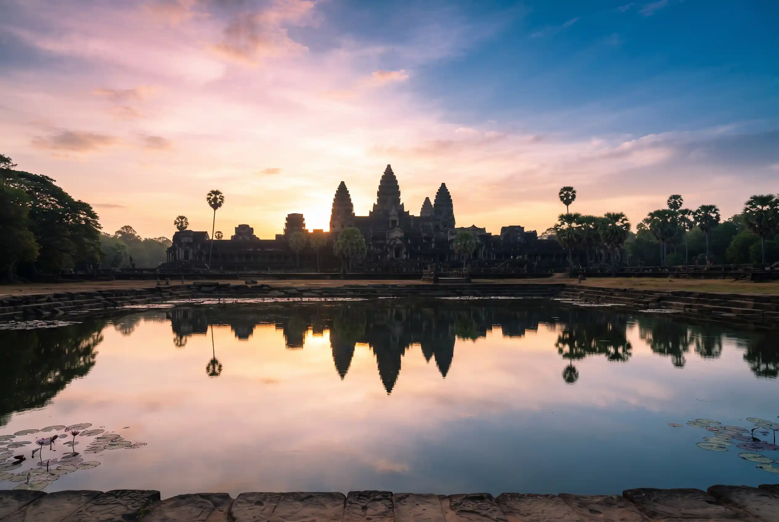 The towers of Angkor Wat reflected in the pond at sunrise