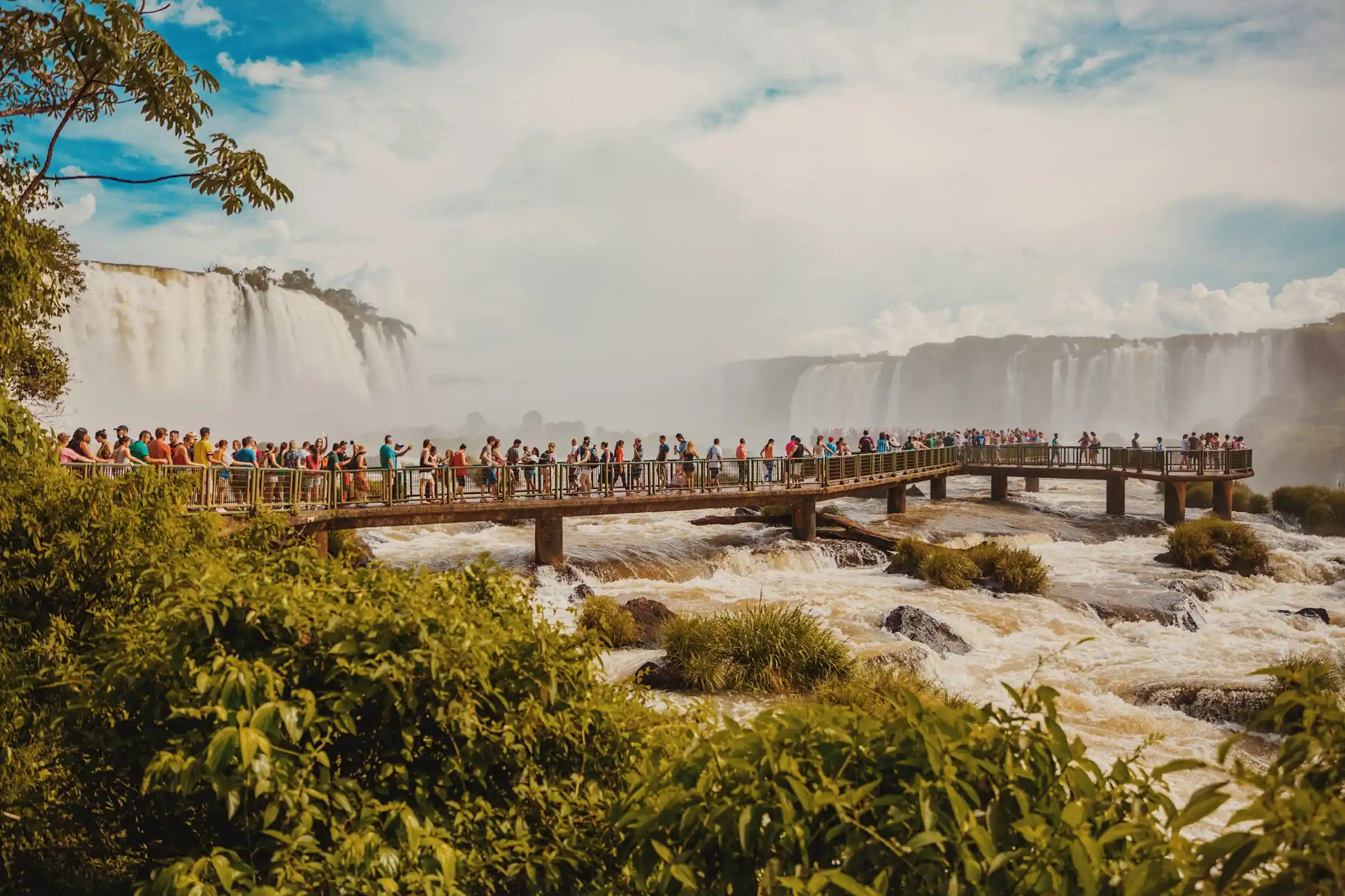 The wide curtain of Iguazu Falls crashing through green rainforest