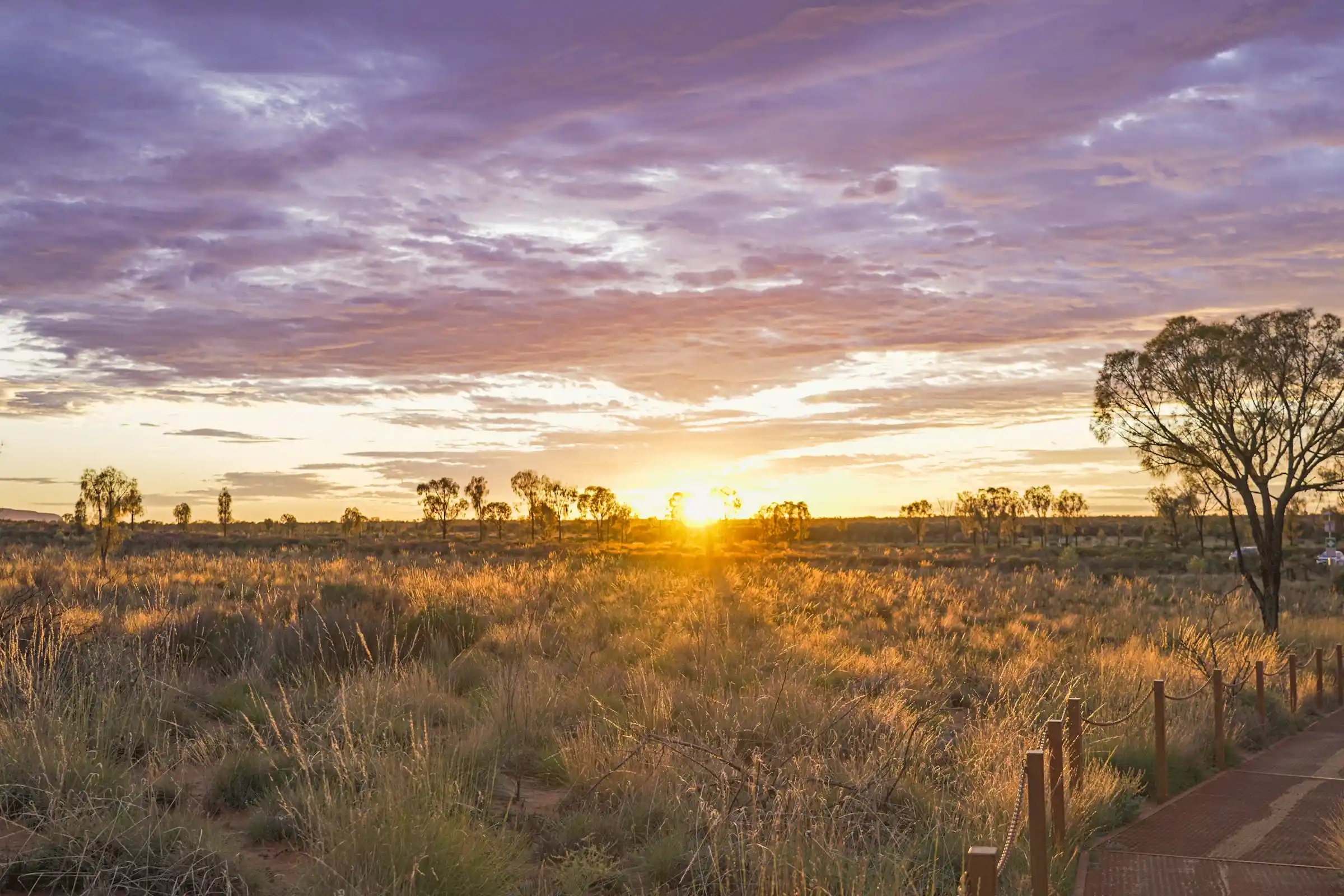 Uluru glowing deep red at sunset under a clear outback sky