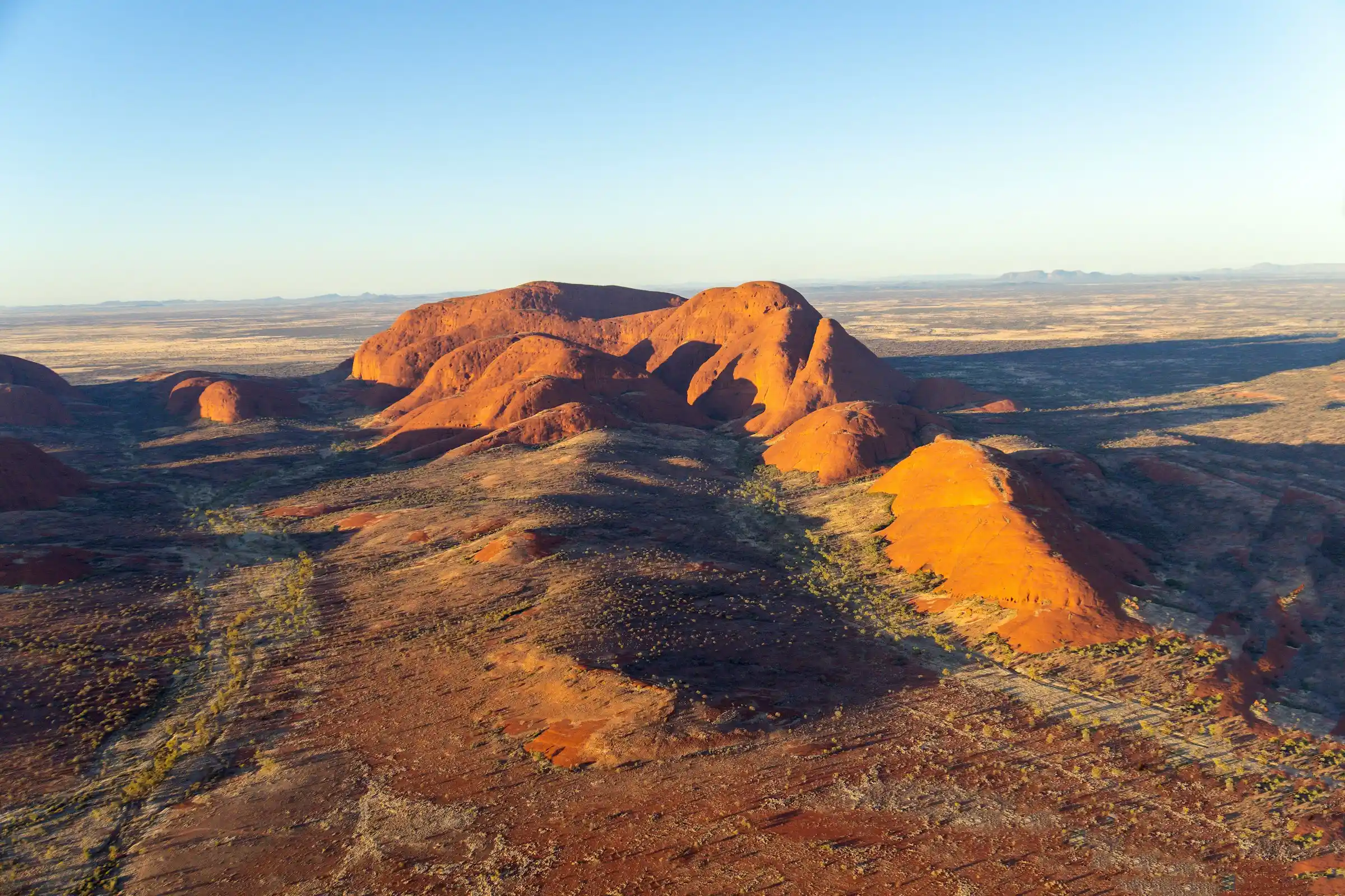 Visitors watching sunrise over Uluru from a desert viewing area