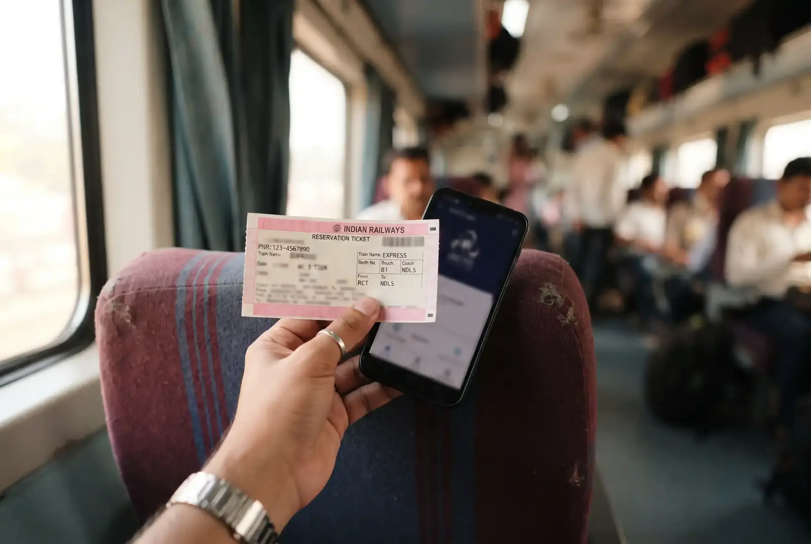 Close-up of an Indian railway reserved ticket and a smartphone on a train seat
