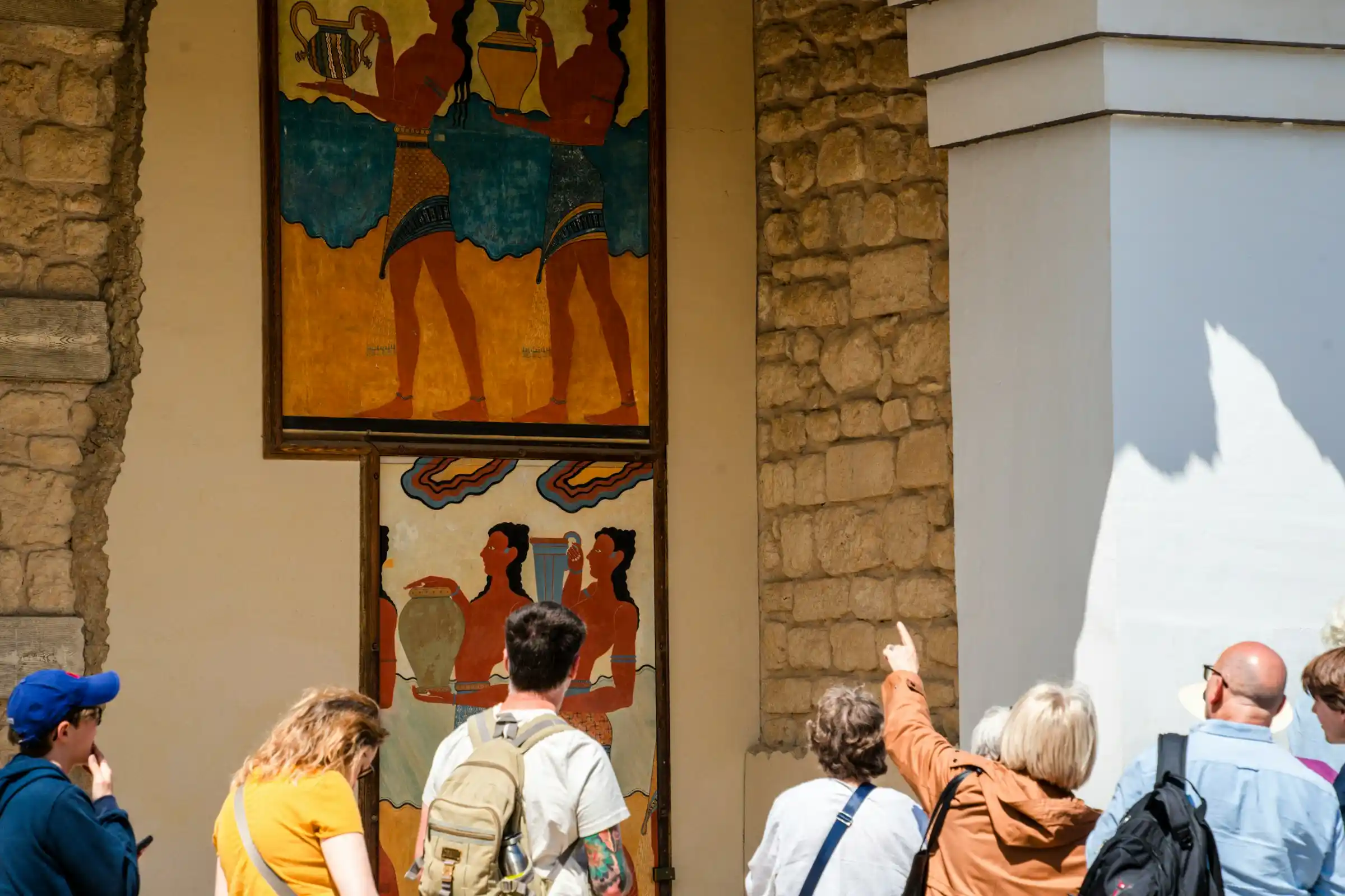 A Minoan fresco of figures on a wall at the Palace of Knossos