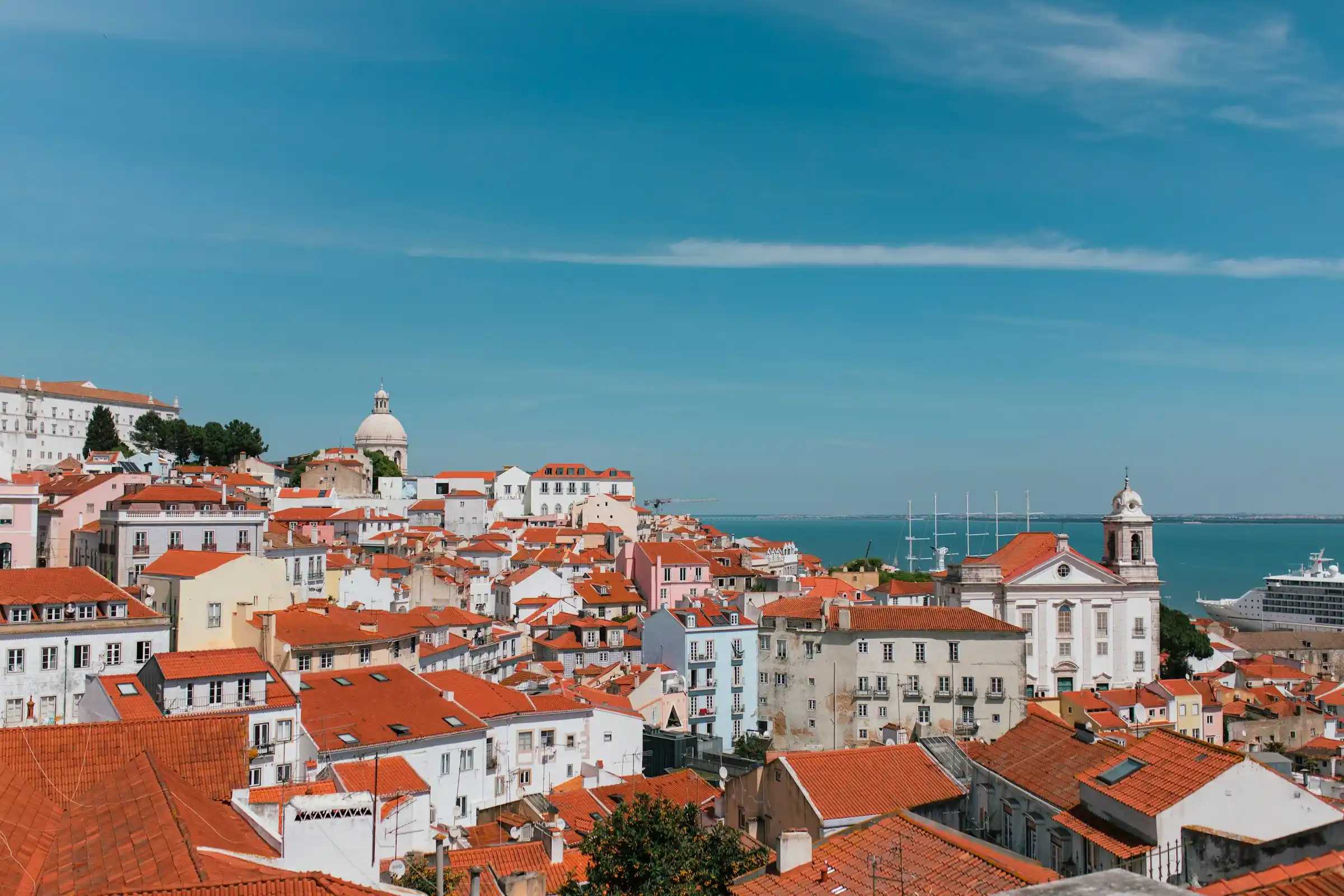 A hilltop miradouro viewpoint over the red rooftops of Lisbon and the Tagus river