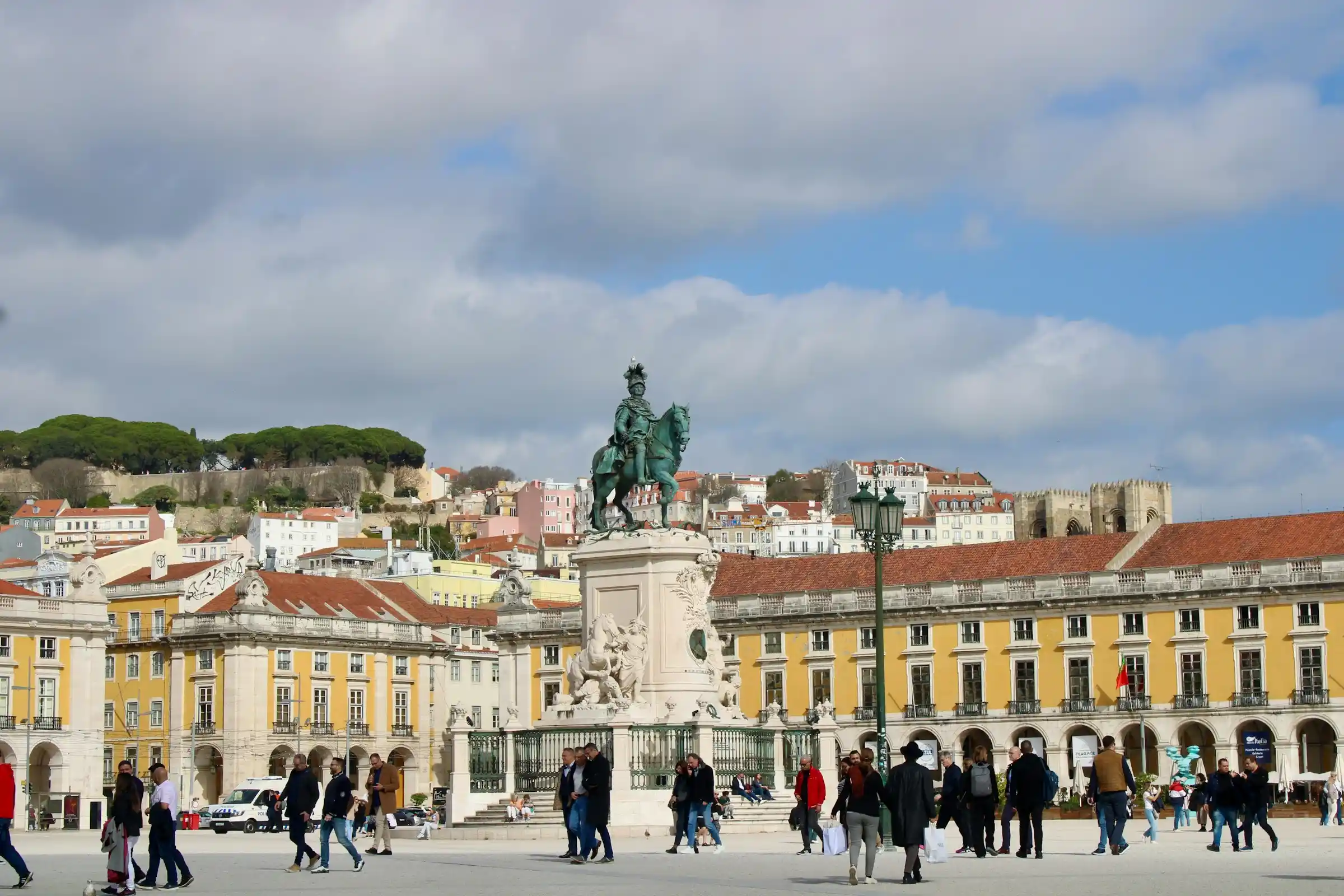 A walking tour group in a historic Lisbon square with pastel buildings