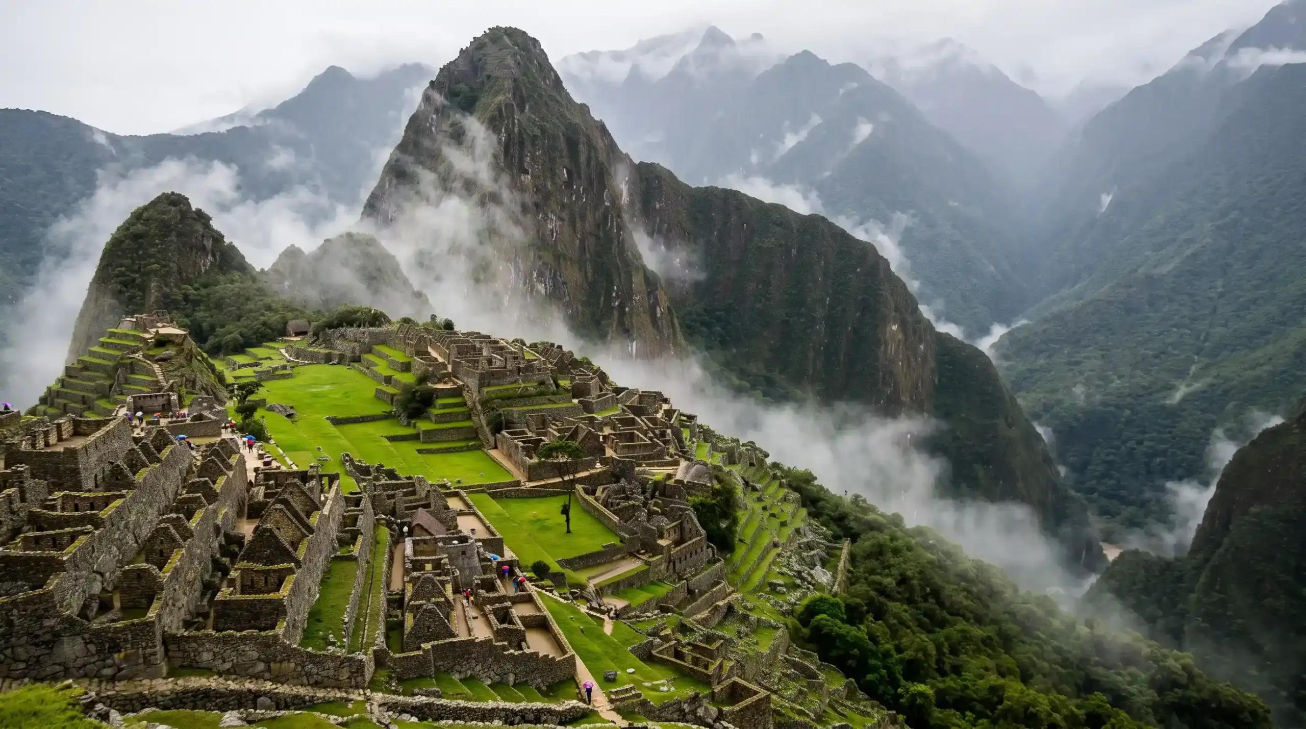 Lush green terraces at Machu Picchu during rainy season with mist