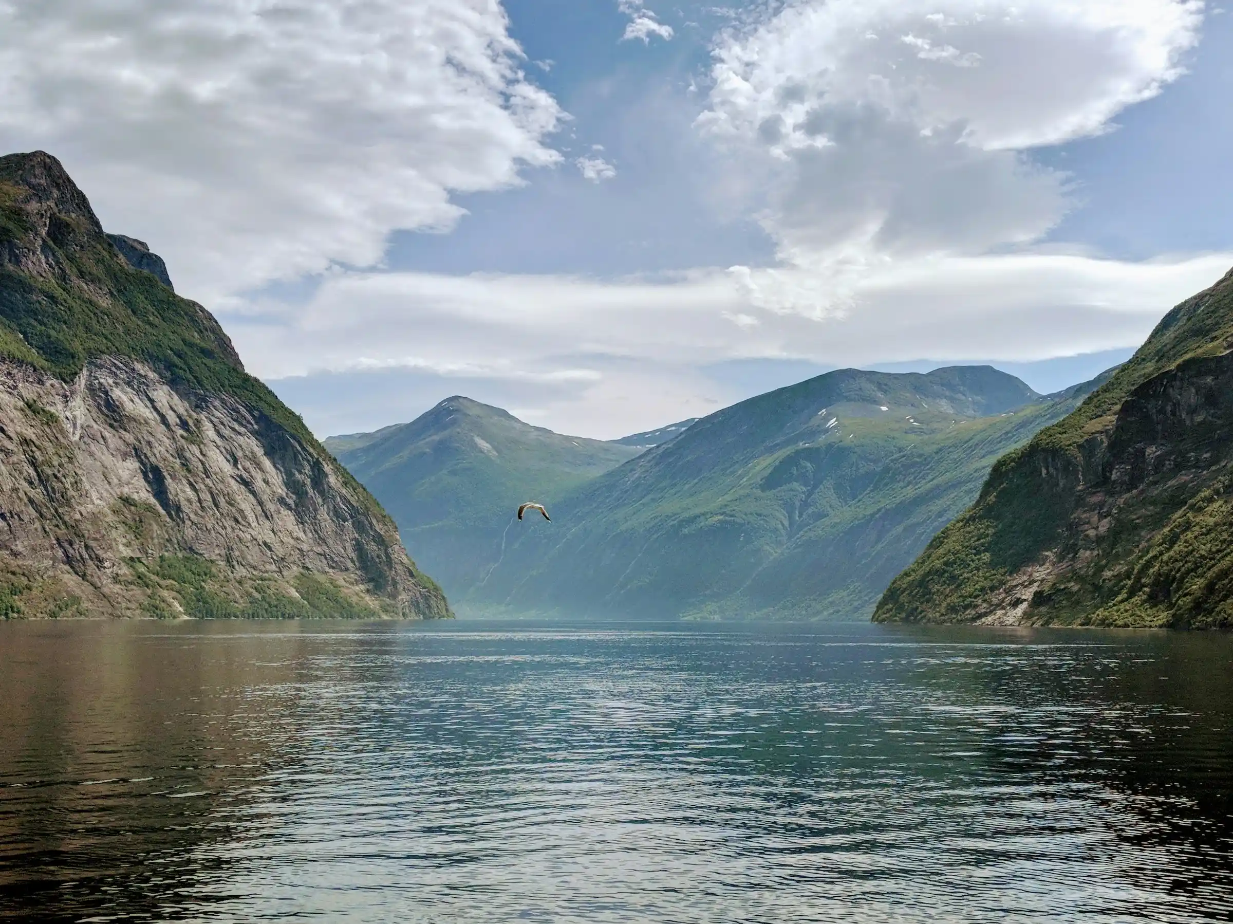 A small ferry sailing through the narrow Naeroyfjord in Norway