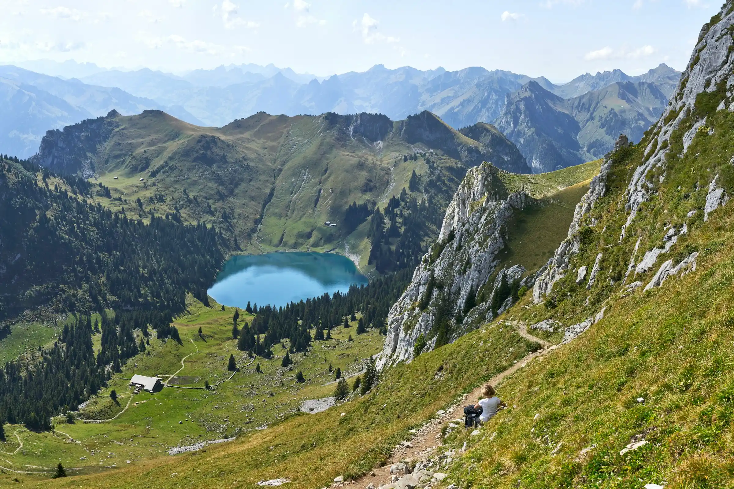 Hikers on a ridge trail with the Eiger and snow peaks behind in the Swiss Alps