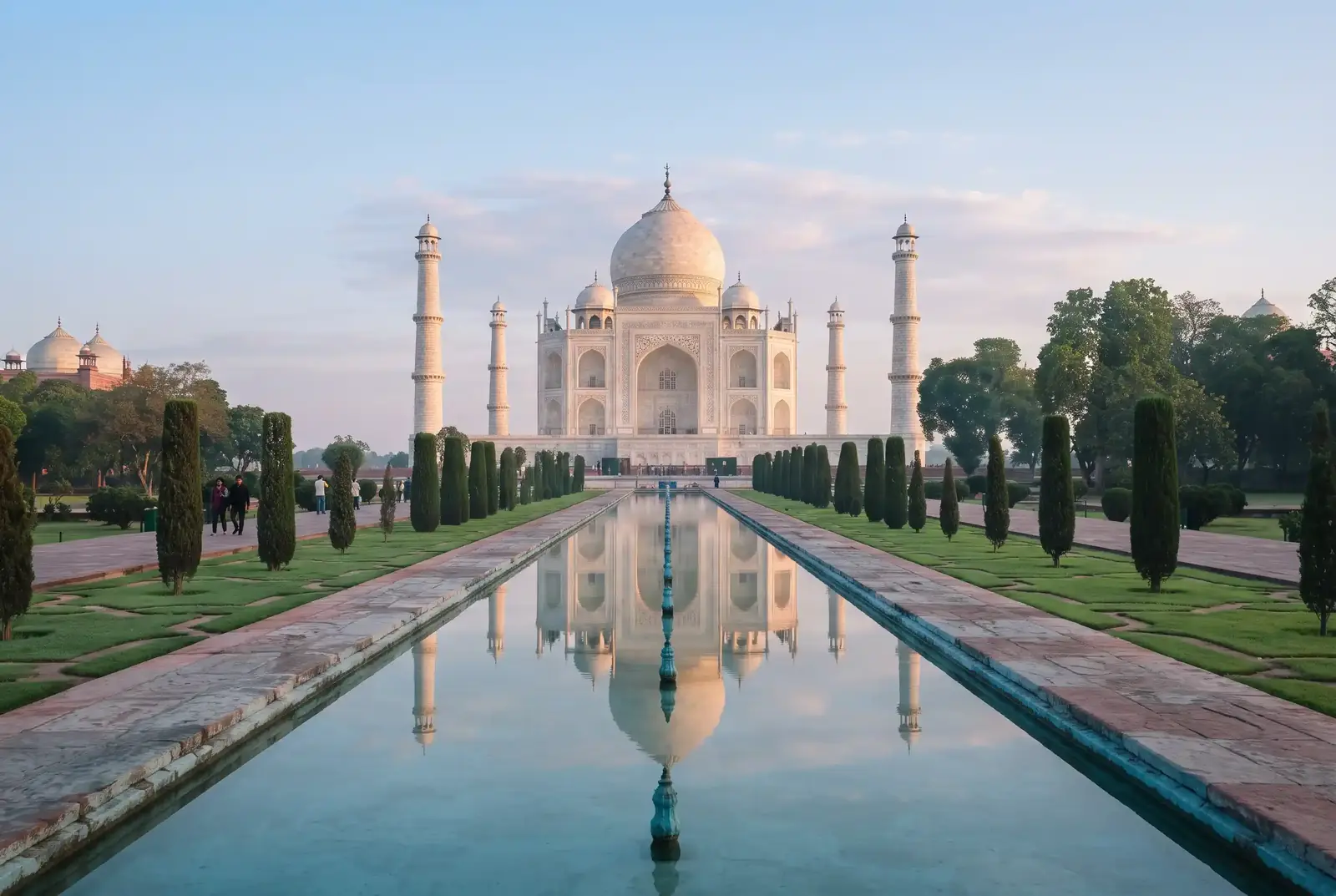 The Taj Mahal reflected in its garden water channel in morning light