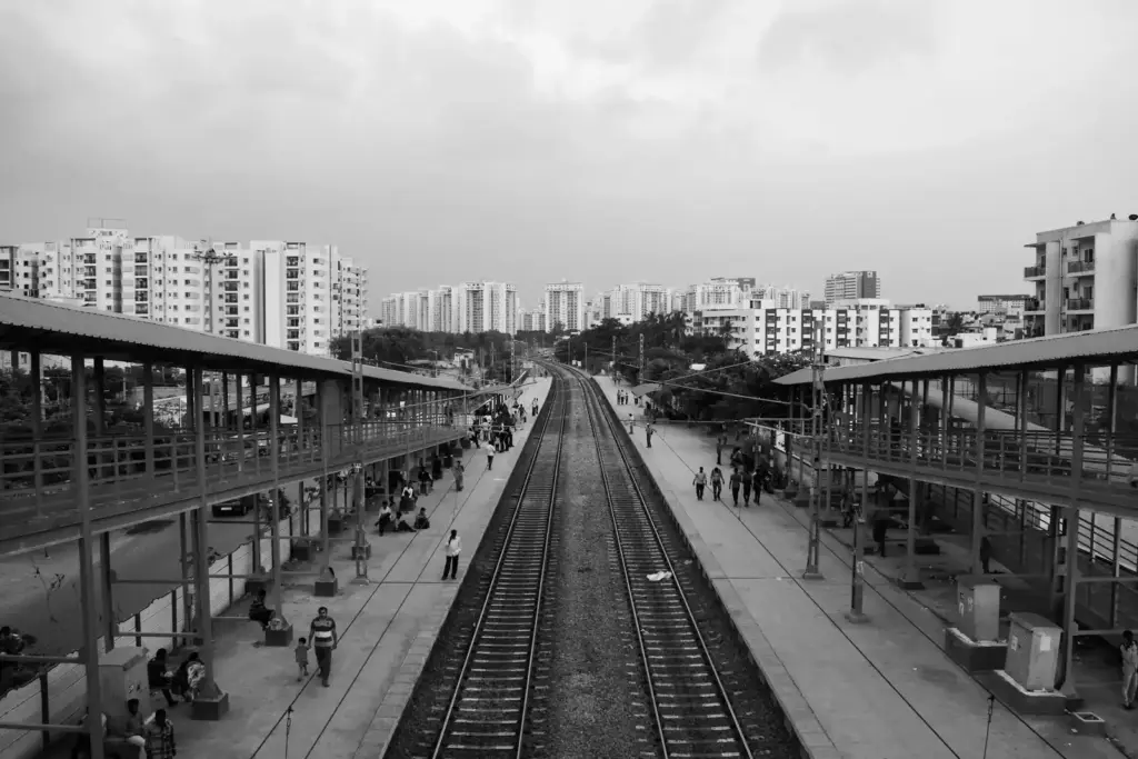 Traveller checking train times on a phone at an Indian railway station platform