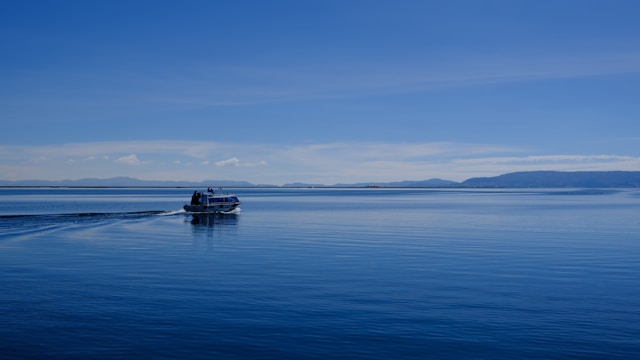 Sandy shoreline of Lake Titicaca near Copacabana with blue water and distant mountains
