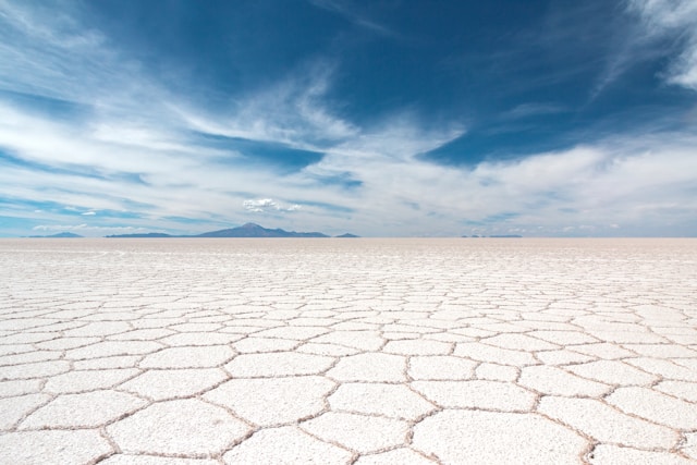 The Salar de Uyuni salt flat in dry season showing the geometric hexagonal salt crust stretching to the horizon