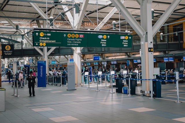 Travellers walking through an airport terminal with departure boards
